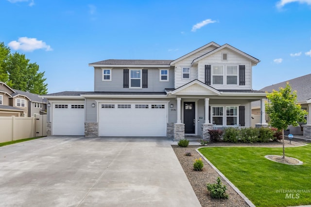 7531 E Lafayette St, Nampa, ID 83687 - view of front facade featuring driveway, stone siding, covered porch, and a garage