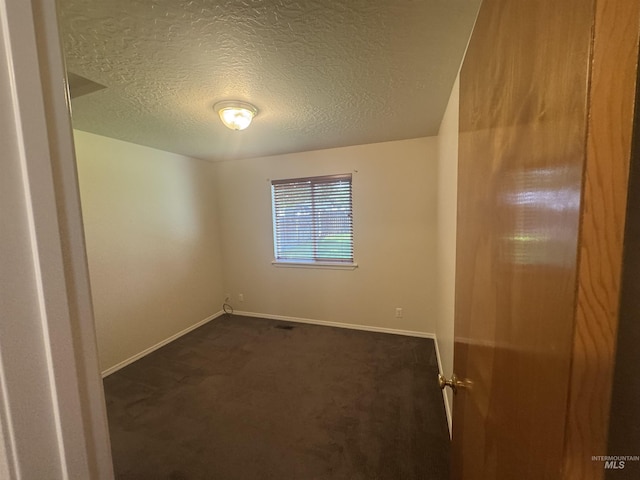 2451 W Park Stone Dr, Meridian, ID 83646 - empty room with dark carpet, baseboards, and a textured ceiling