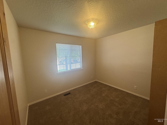 2451 W Park Stone Dr, Meridian, ID 83646 - spare room with dark carpet, baseboards, and a textured ceiling