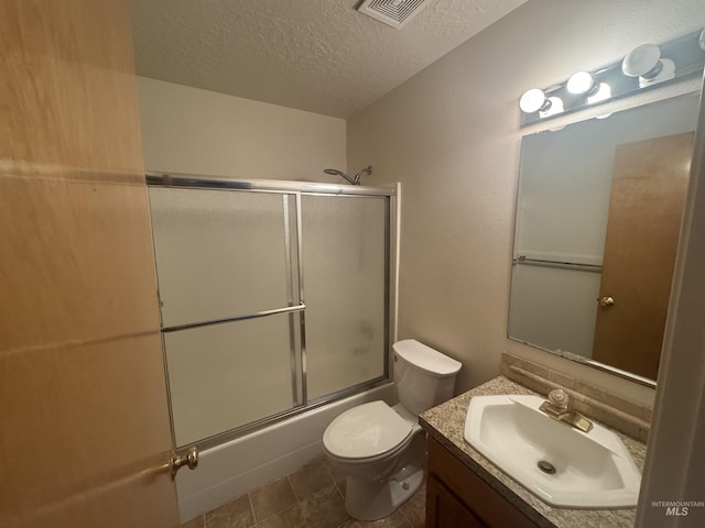 2451 W Park Stone Dr, Meridian, ID 83646 - full bath with a textured ceiling, vanity, bath / shower combo with glass door, and toilet