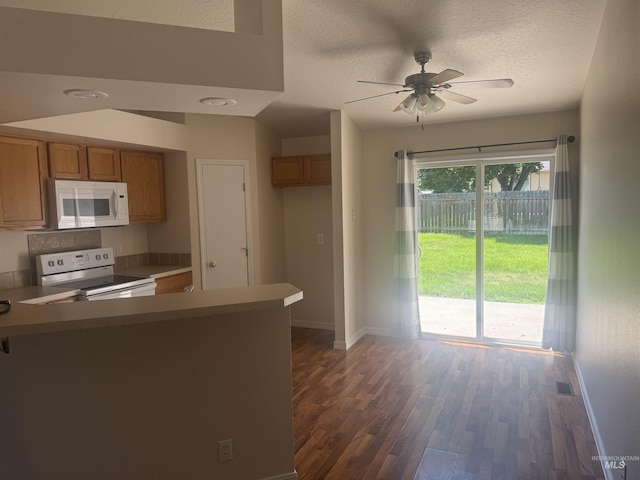 2451 W Park Stone Dr, Meridian, ID 83646 - kitchen with white appliances, brown cabinets, baseboards, a peninsula, and dark wood finished floors