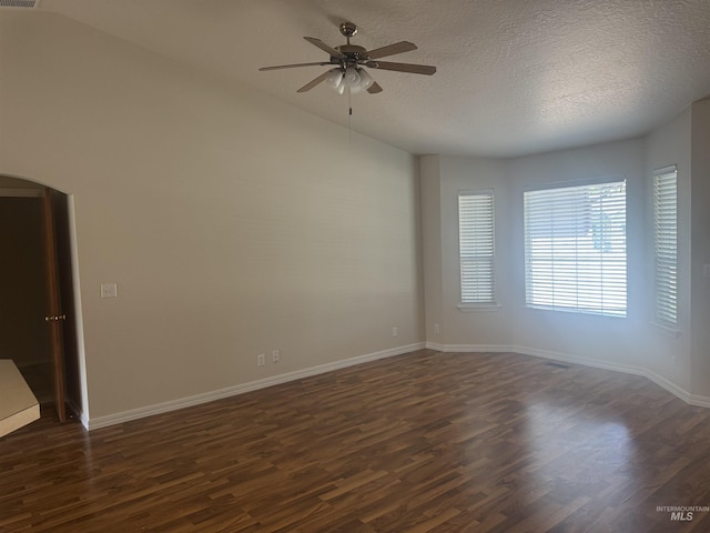 2451 W Park Stone Dr, Meridian, ID 83646 - empty room featuring arched walkways, dark wood finished floors, a ceiling fan, a textured ceiling, and baseboards