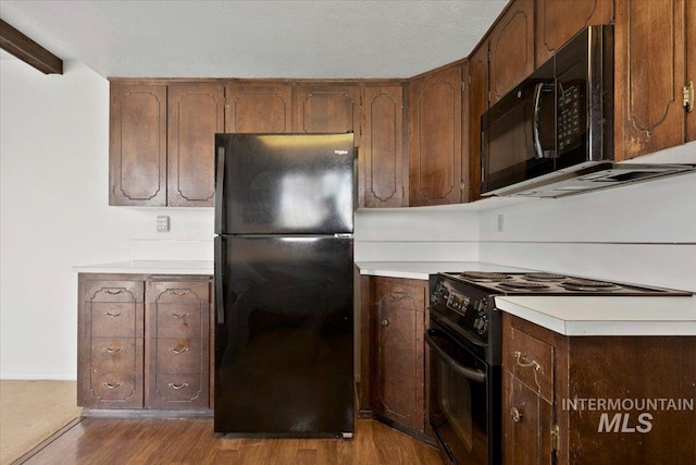 kitchen with hardwood / wood-style floors and black appliances