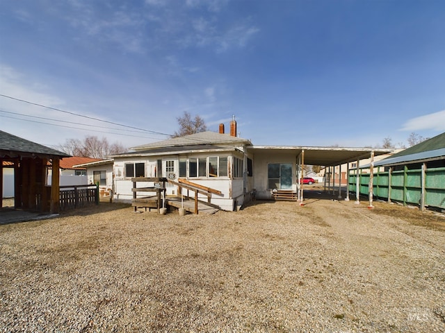 rear view of house with entry steps and a carport