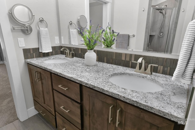 full bath with tile patterned floors, a sink, a shower stall, and double vanity