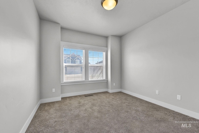 carpeted empty room featuring visible vents and baseboards