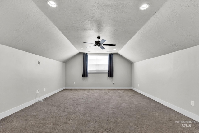 additional living space with lofted ceiling, carpet floors, a textured ceiling, and baseboards