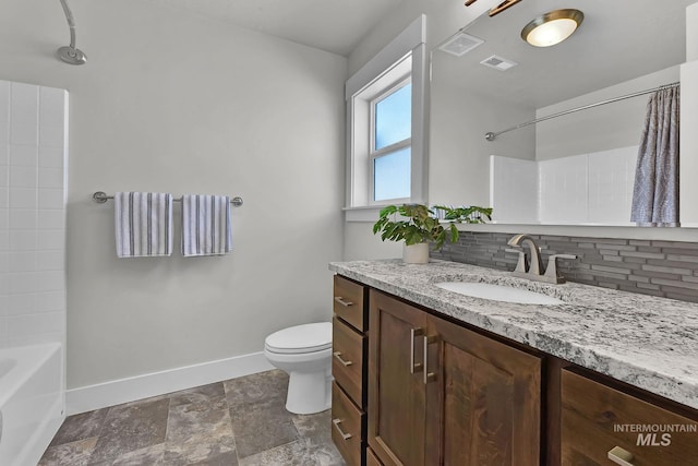 bathroom with toilet, backsplash, visible vents, and baseboards