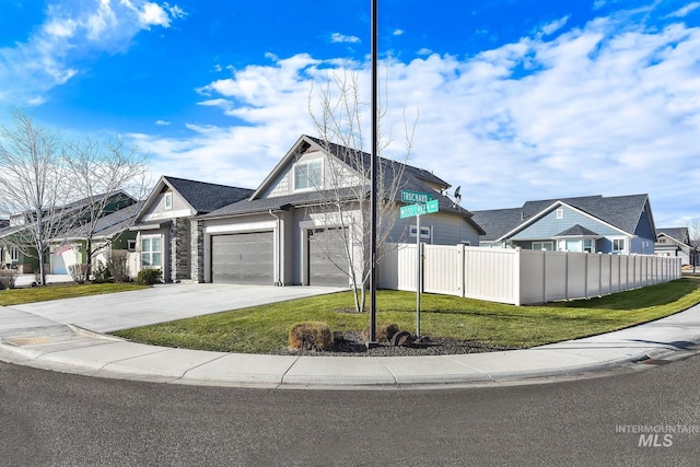 view of front facade with driveway, a garage, a residential view, fence, and a front yard