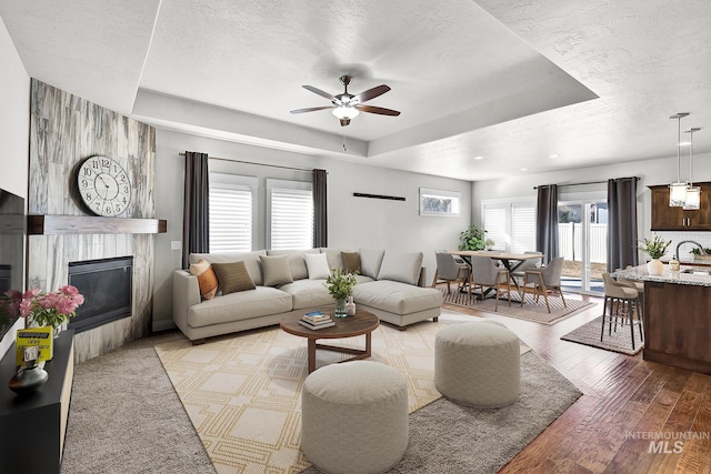 living area featuring light wood-style floors, a wealth of natural light, and a textured ceiling