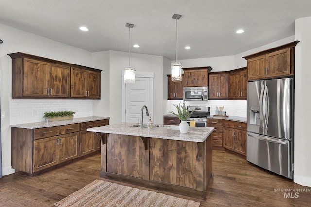 kitchen featuring dark wood finished floors, light stone counters, stainless steel appliances, and a sink