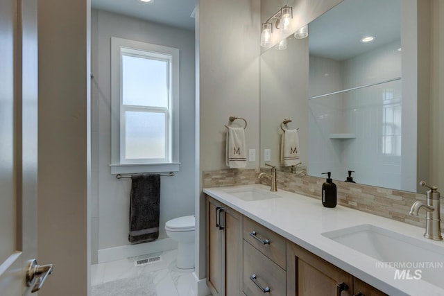 bathroom featuring decorative backsplash, toilet, and vanity