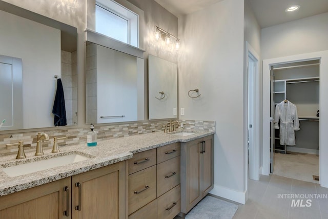 bathroom featuring tile patterned flooring, decorative backsplash, and vanity