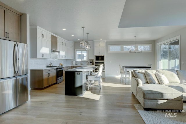 kitchen featuring pendant lighting, white cabinetry, a center island, and stainless steel appliances