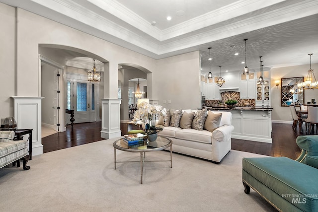724 E Lakebrook Ln, Eagle, ID 83616 - living room featuring a chandelier, arched walkways, hardwood / wood-style floors, a raised ceiling, and crown molding