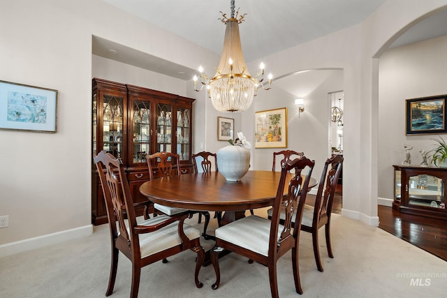 724 E Lakebrook Ln, Eagle, ID 83616 - dining space with arched walkways, light colored carpet, and a chandelier