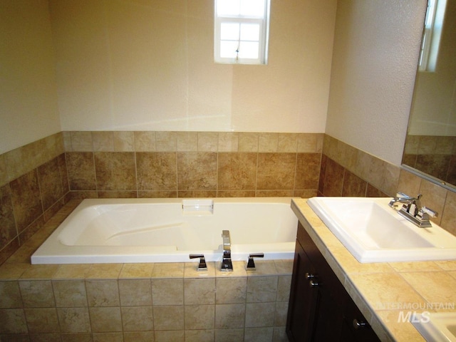 full bathroom with vanity and a bath