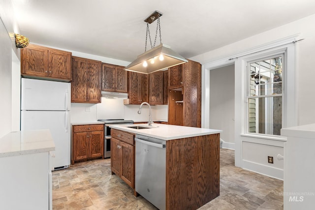 kitchen with an island with sink, stone finish flooring, stainless steel appliances, under cabinet range hood, and a sink