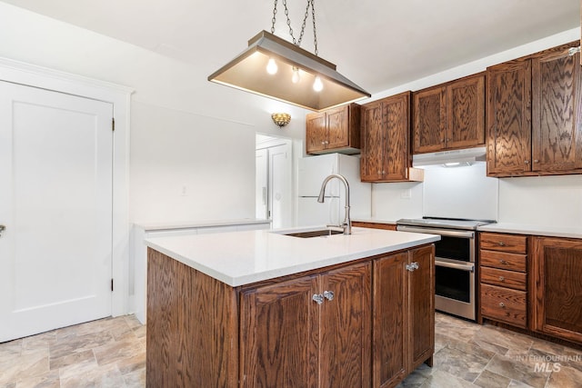 kitchen with range with two ovens, stone finish flooring, light countertops, and under cabinet range hood