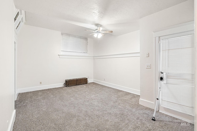 carpeted empty room featuring a textured ceiling, baseboards, and a ceiling fan