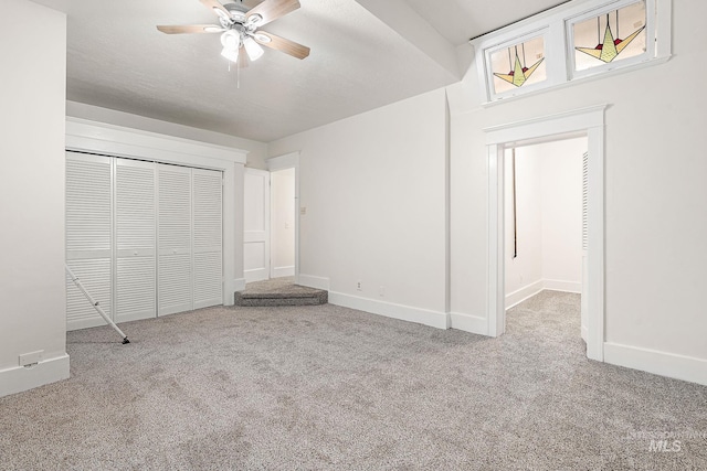 unfurnished bedroom featuring ceiling fan, a closet, baseboards, and carpet flooring