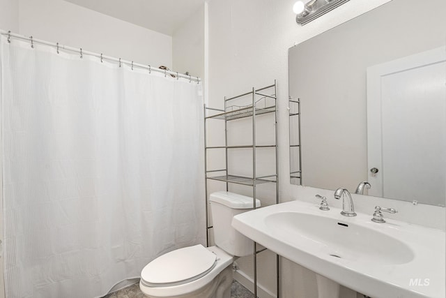 full bath featuring a shower with shower curtain, a sink, and toilet