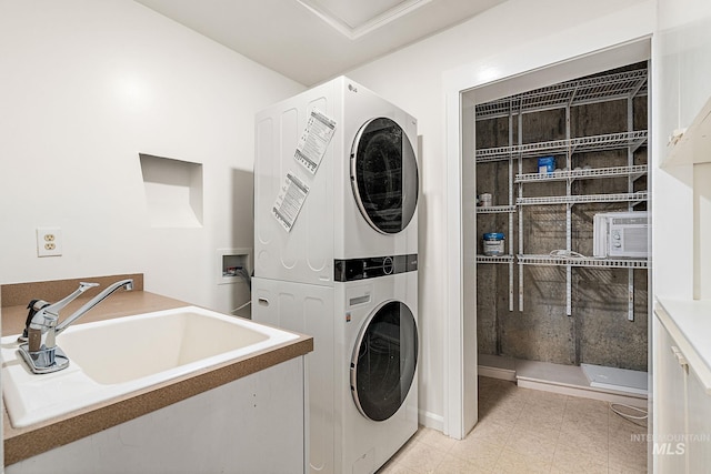 laundry area with stacked washer and dryer, laundry area, and a sink