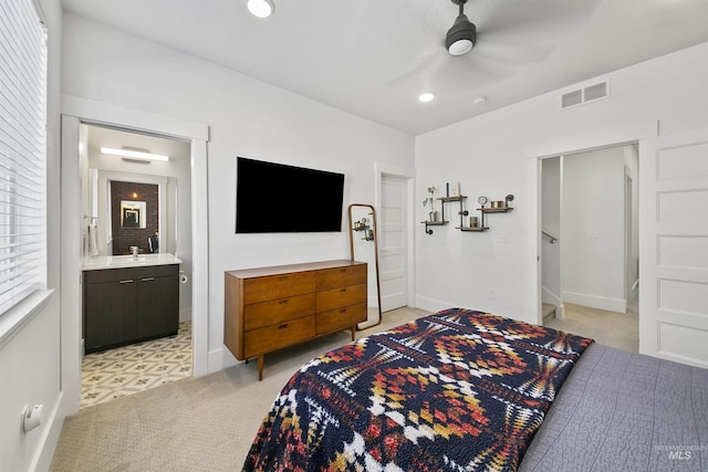 carpeted bedroom featuring sink, ensuite bath, and ceiling fan