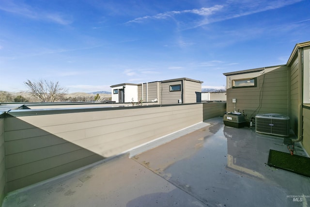 view of side of property with a patio, central AC, and a mountain view