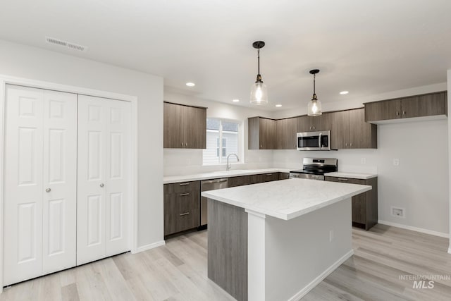 672 S Jayo Ct, Emmett, ID 83617 - kitchen featuring backsplash, sink, light hardwood / wood-style floors, appliances with stainless steel finishes, and a kitchen island