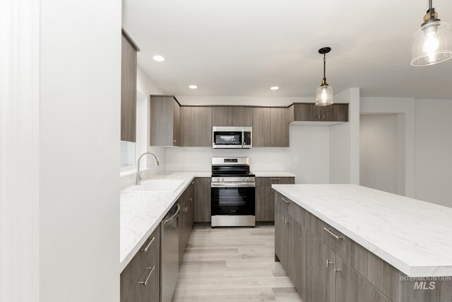 672 S Jayo Ct, Emmett, ID 83617 - kitchen with stainless steel appliances, a kitchen island, a healthy amount of sunlight, and sink
