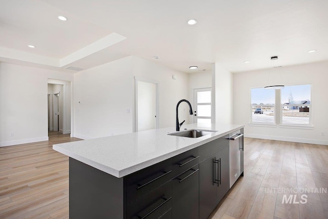 kitchen featuring recessed lighting, a sink, a center island with sink, and light wood-style floors