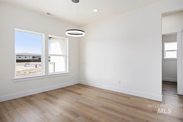 spare room with light wood-style floors, baseboards, visible vents, and recessed lighting