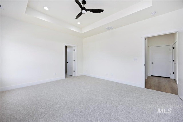 unfurnished room featuring recessed lighting, a raised ceiling, visible vents, a ceiling fan, and baseboards