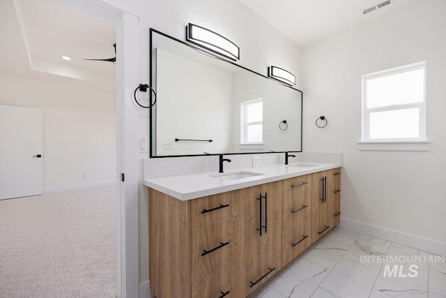 bathroom with a wealth of natural light, visible vents, and a sink