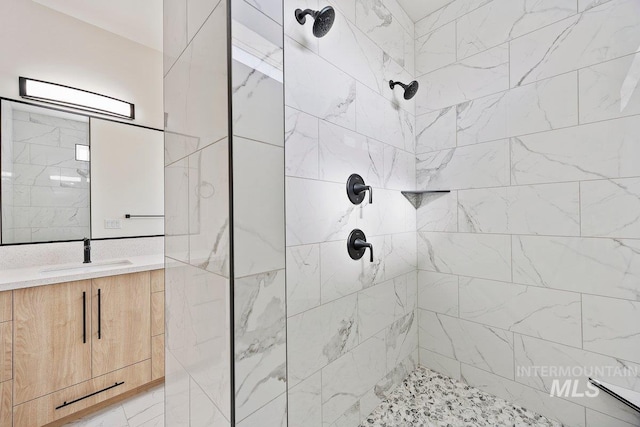 bathroom featuring tiled shower and vanity