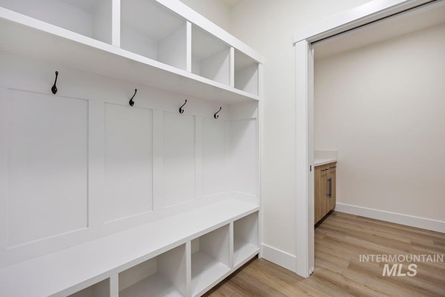 mudroom featuring light wood-style flooring and baseboards