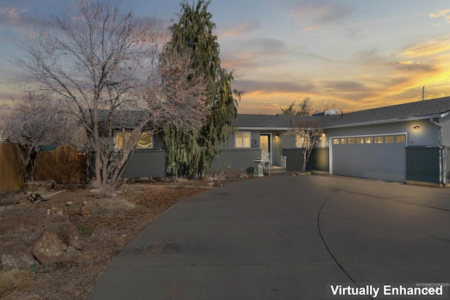 ranch-style house with brick siding, a shingled roof, fence, concrete driveway, and a garage