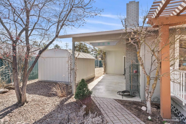 view of patio / terrace with an outbuilding, a storage shed, and a pergola