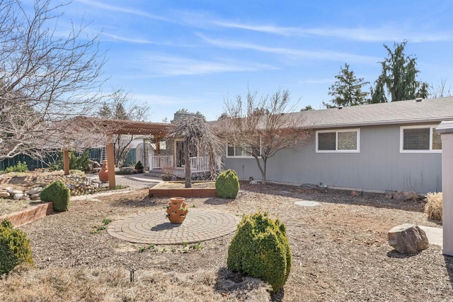 rear view of property with a pergola and roof with shingles