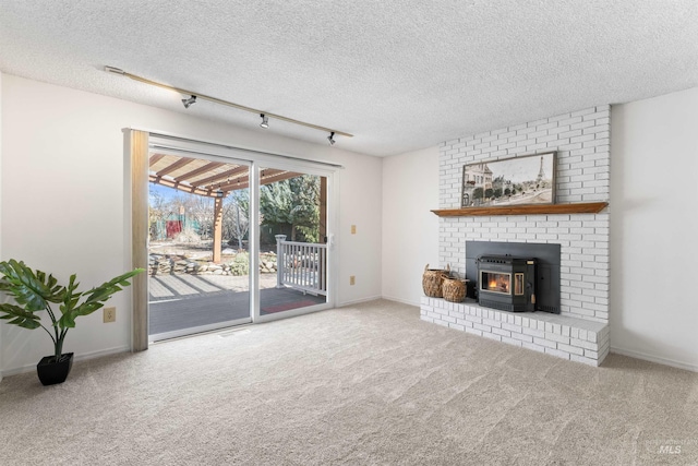 unfurnished living room featuring baseboards, carpet, rail lighting, and a textured ceiling