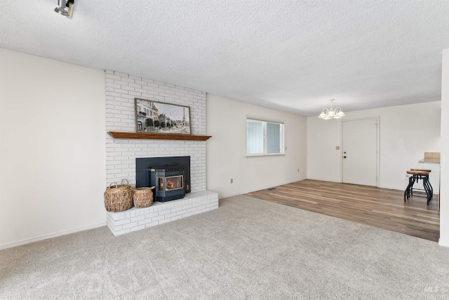 unfurnished living room with a chandelier, a textured ceiling, and carpet floors