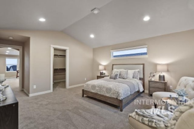 bedroom with multiple windows, a spacious closet, vaulted ceiling, and light carpet