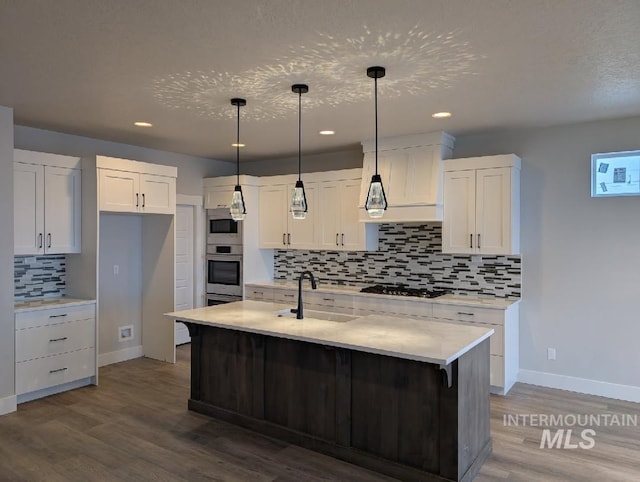 kitchen with white cabinetry, dark wood-style flooring, a sink, and gas cooktop