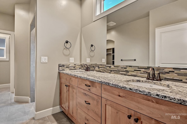 full bathroom with decorative backsplash, tile patterned flooring, and a sink