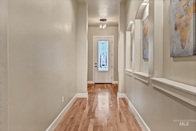 doorway to outside featuring light wood-type flooring and baseboards