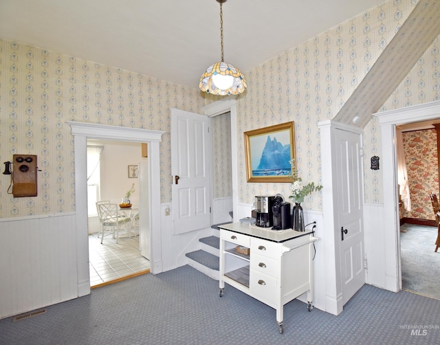 hallway with wainscoting, visible vents, carpet flooring, and wallpapered walls