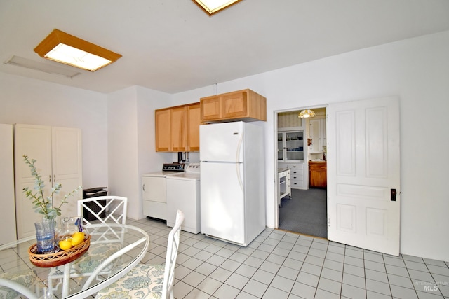 kitchen featuring freestanding refrigerator, light countertops, independent washer and dryer, and light tile patterned floors