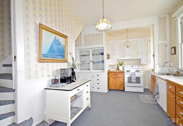 kitchen featuring pendant lighting, a wainscoted wall, light countertops, white appliances, and wallpapered walls