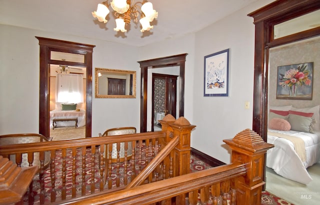 corridor with an inviting chandelier and an upstairs landing